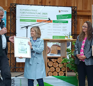 Klimaschutzministerin Katrin Eder überreicht Forstamtsleiter Friedbert Ritter das Zertifikat „Holz von Hier®“